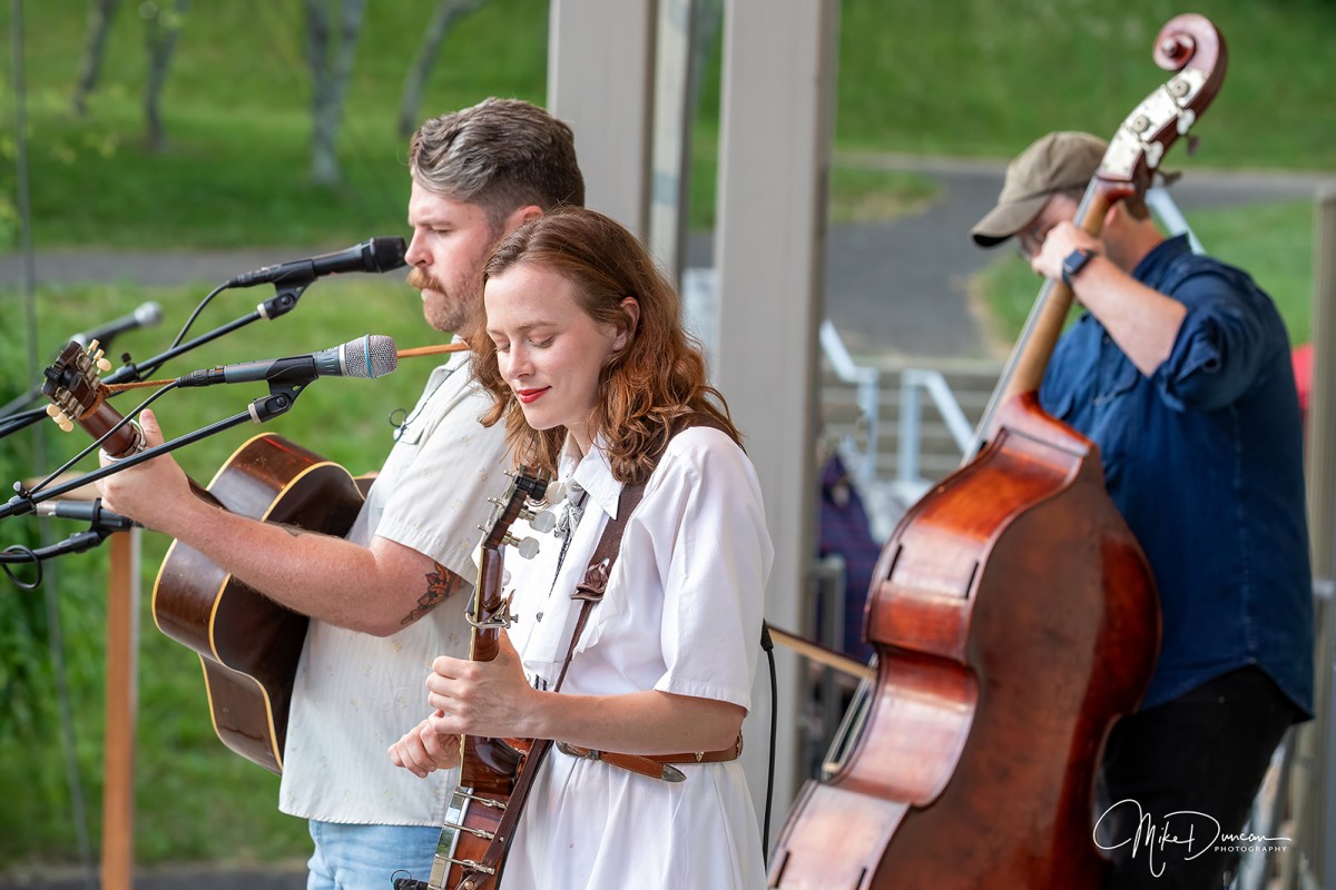 Sarah McCombie plays banjo and Austin McCombie plays guitar on the amphitheater stage at the Blue Ridge Music Center