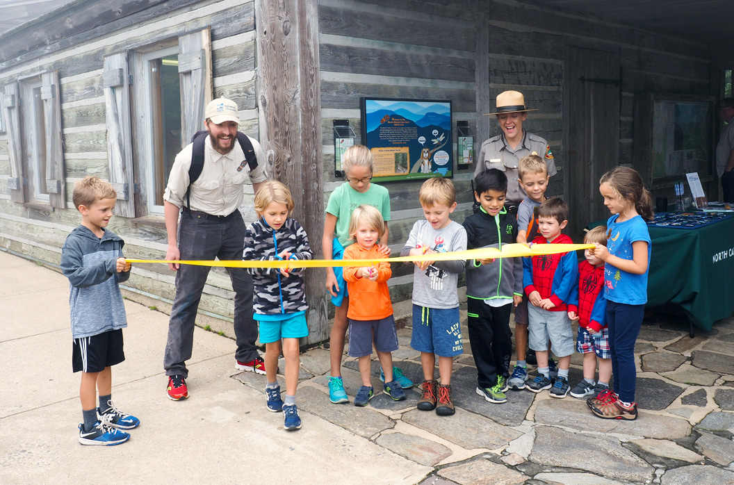 Children line up to cut a ribbon to open a new Kids in Parks trail at Mount Mitchell