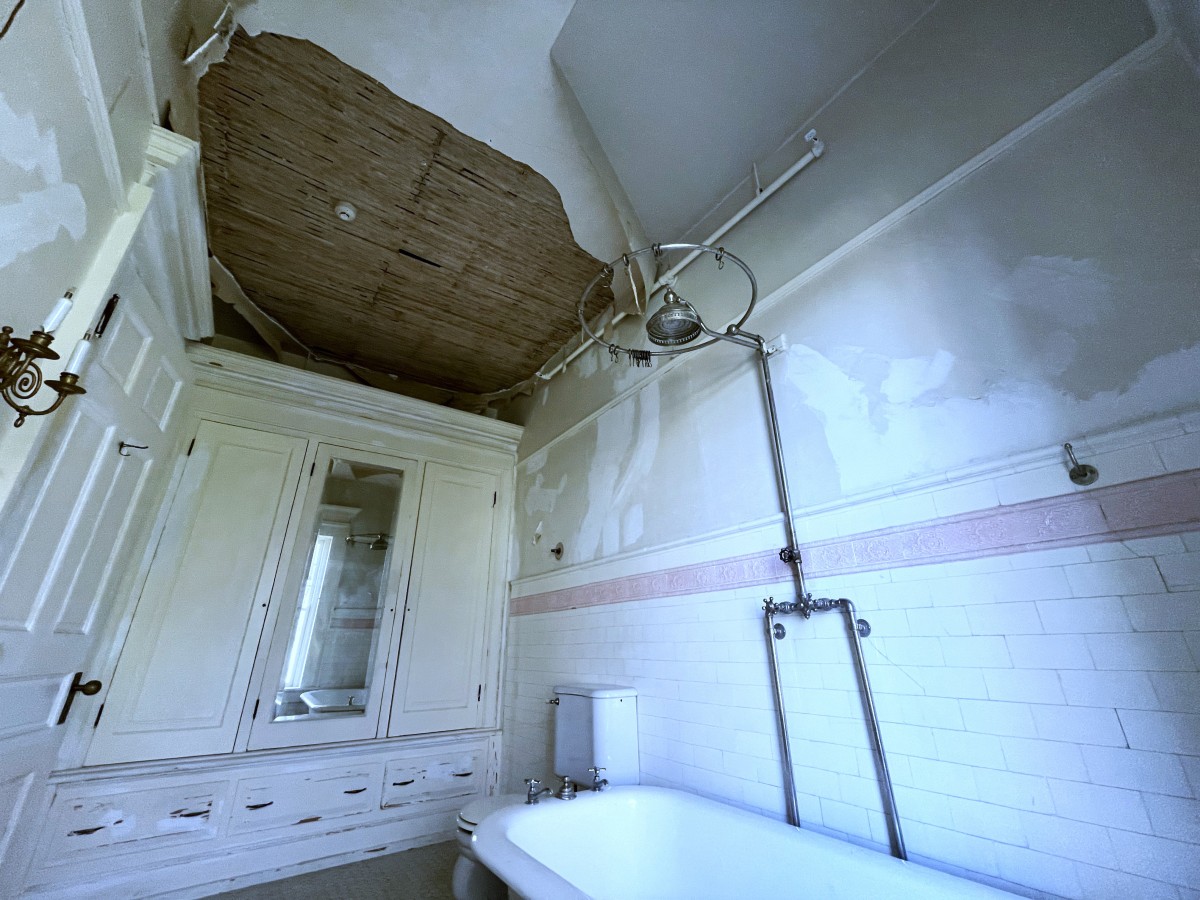 View of damaged and missing plaster on ceiling at Flat Top Manor