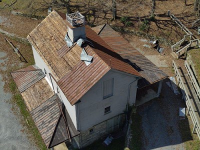 An aerial photo of of the damaged roof of the carriage barn at Moses H. Cone Memorial Park