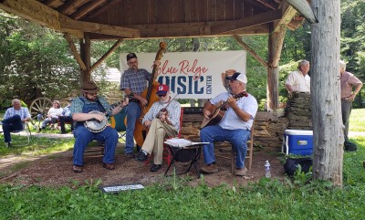 A group of musicians plays for visitors during a Milepost Music session at Mabry Mill.