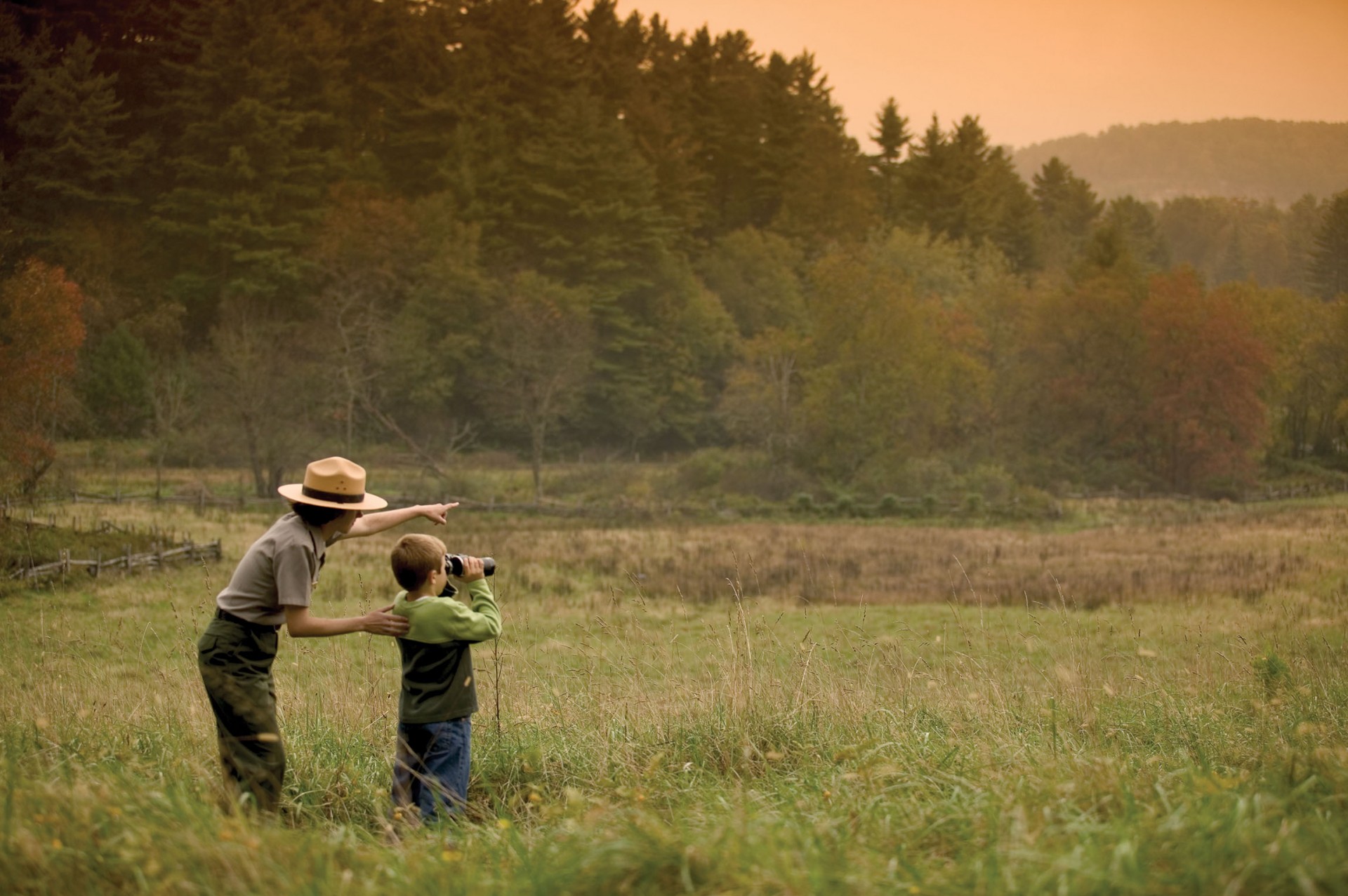 NPS ranger assists a young visitor in a field